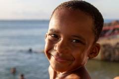 Criança sorrindo ao entardecer na Ponta do Mutá